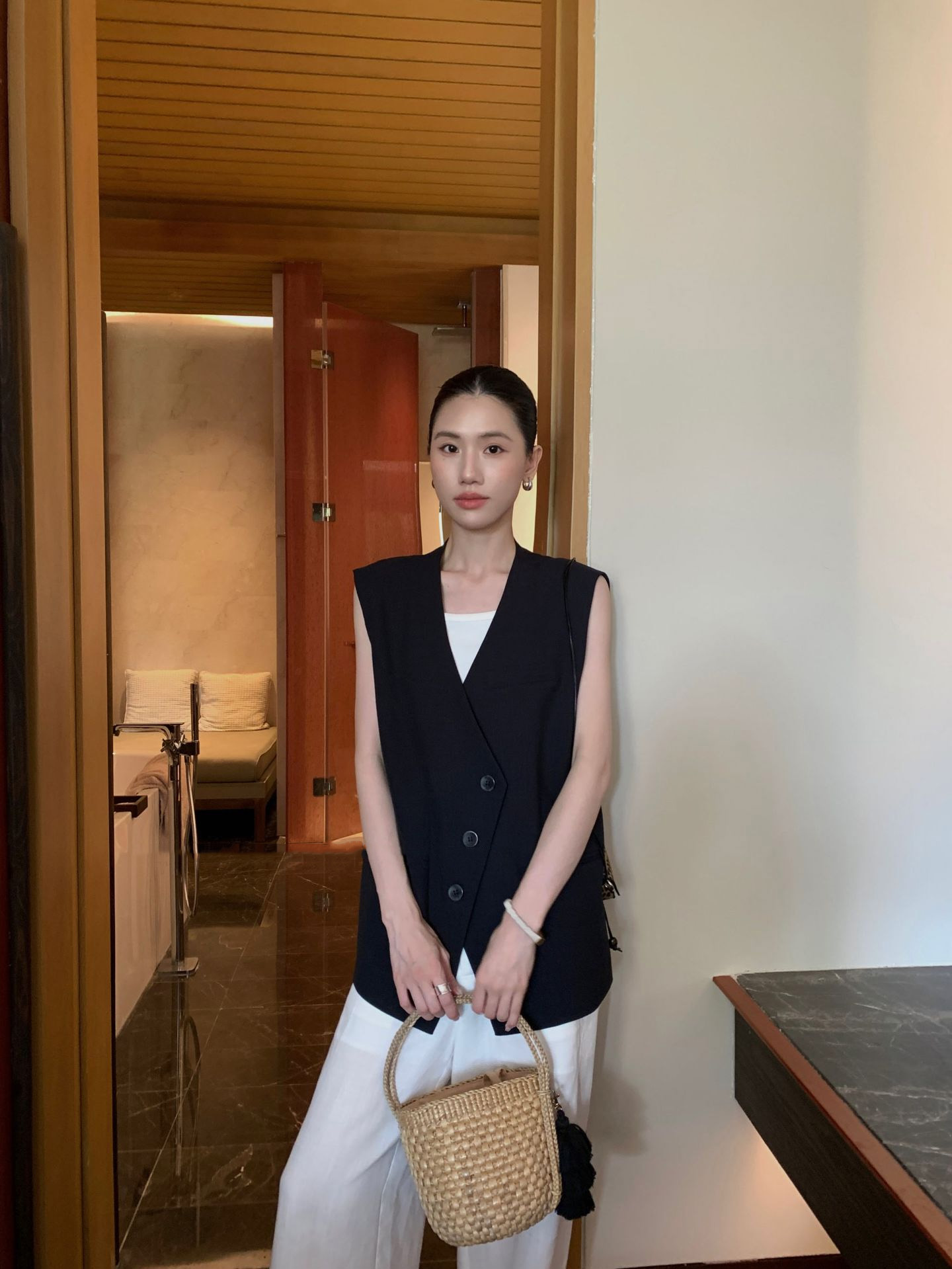 ブラックジレベスト×ホワイトタンクトップ×ワイドパンツ×レザーバッグのコーディネート例